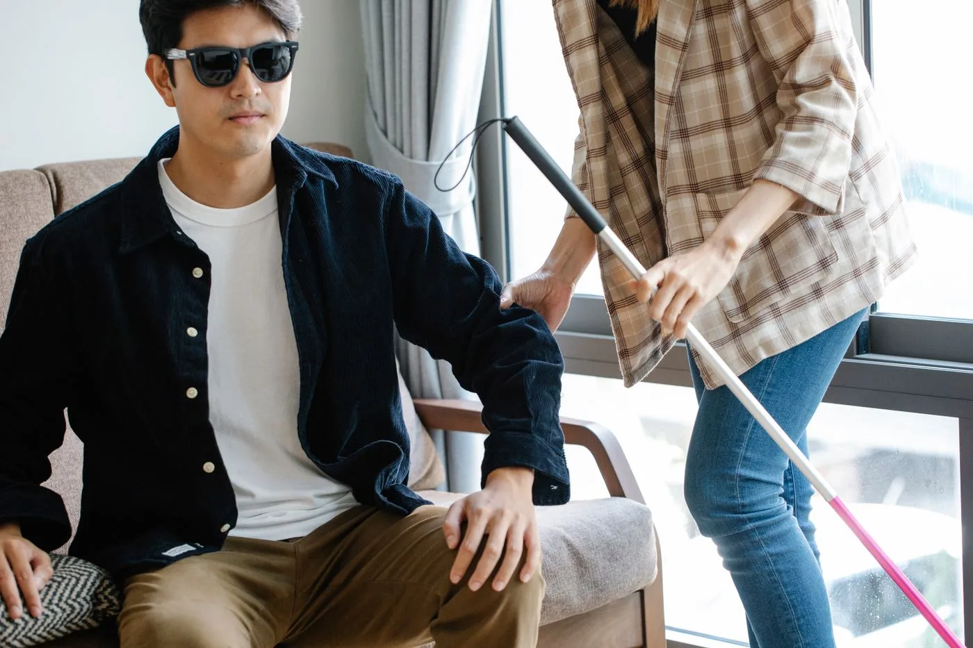 Support worker helping a man with vision impairment at home